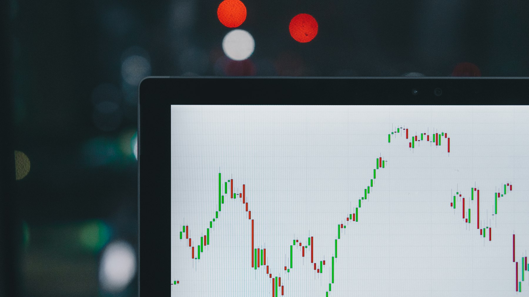 A candlestick chart on a monitor in a dark room